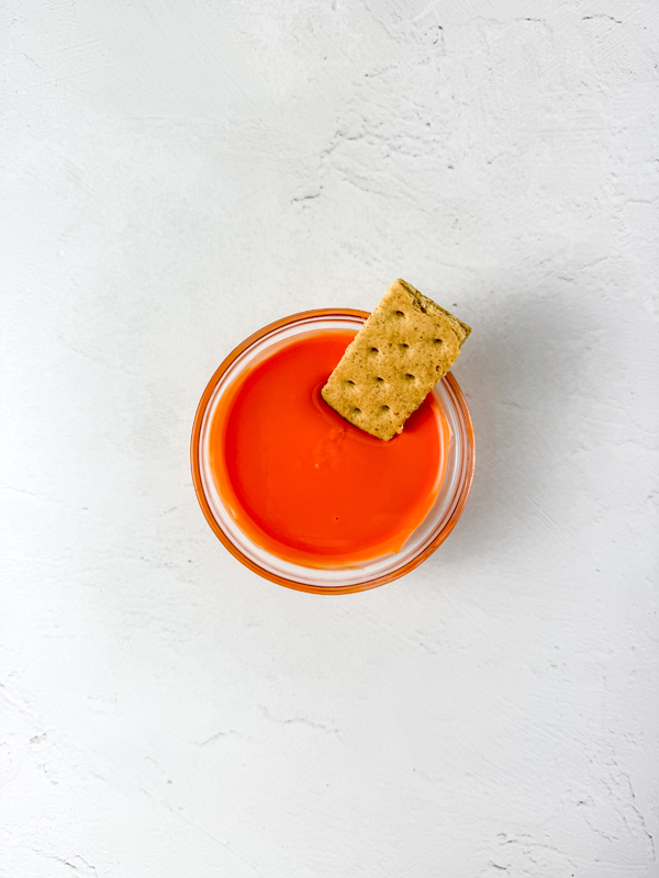 dip rounded edges of graham crackers into melted orange candy