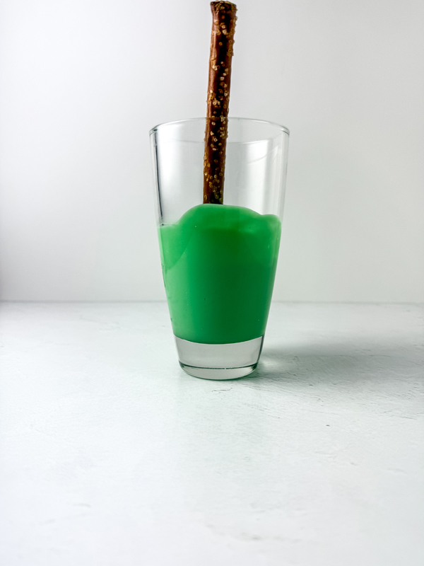 dip the pretzel rod in the melted green candy