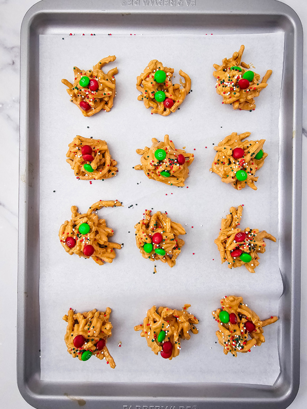lightly press m&ms and sprinkles to the top of the haystack mixture