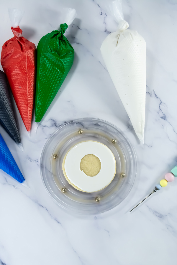 create a ring round the tops of the cookies with white icing, leaving a ring in the center