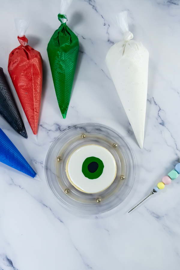 add the black icing to the center to create pupils
