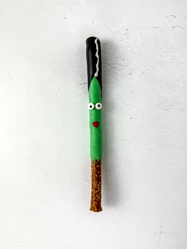 add the candy eyes and create lips with the red candy