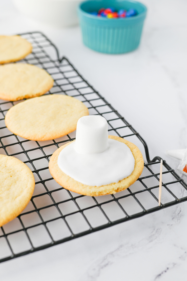 add icing and a marshmallow to each cookie