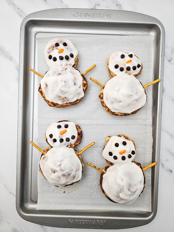 create the snowman faces with the chocolate chips and icing