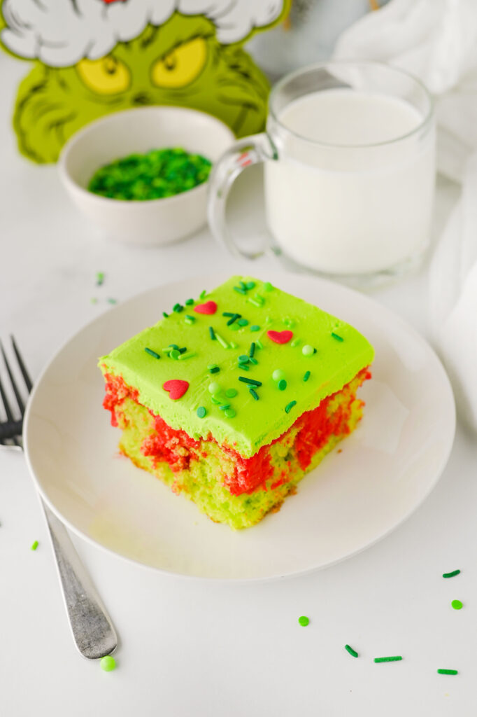 slice of christmas grinch poke cake on a plate
