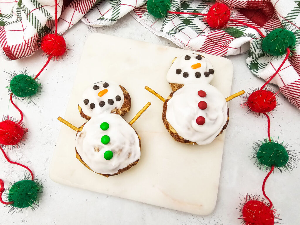 cute snowman cinnamon rolls on a counter