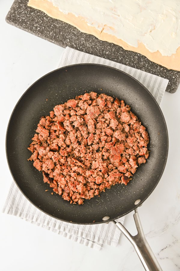 brown and chop the sausage in a skillet