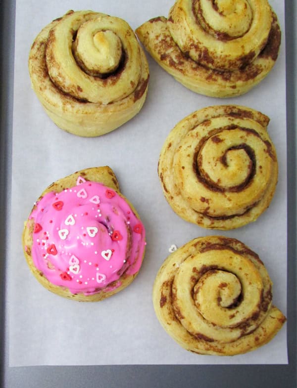 closeup of decorated cinnamon roll on a baking sheet