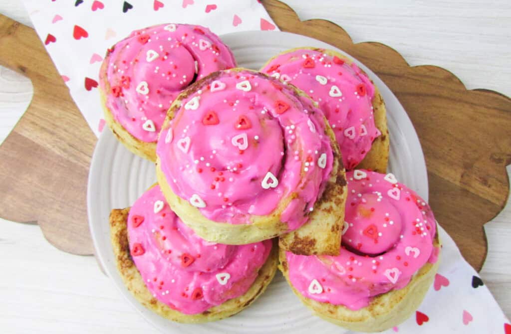 pink heart valentine's day cinnamon rolls on a plate